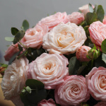 Кустовые розы с зеленью в шляпной коробке