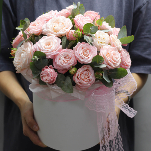 Кустовые розы с зеленью в шляпной коробке